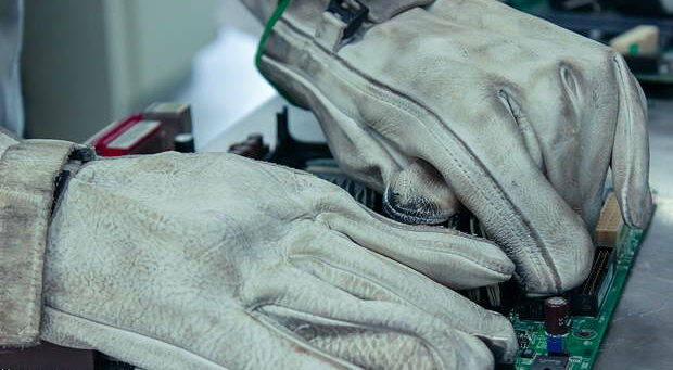 Worker dismantling and cleaning of print circuit board PCB for its recycling