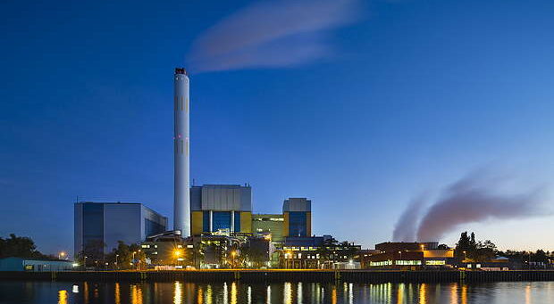 Colorful evening view of a modern waste incineration plant in Oberhausen, Germany with blue sky.